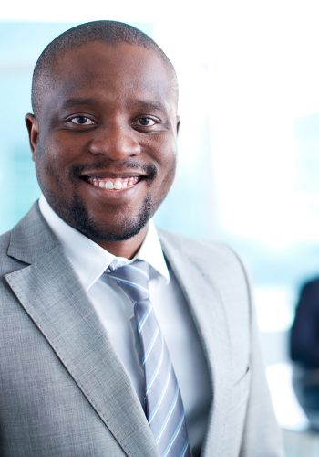 Image of African-American business leader looking at camera in working environment